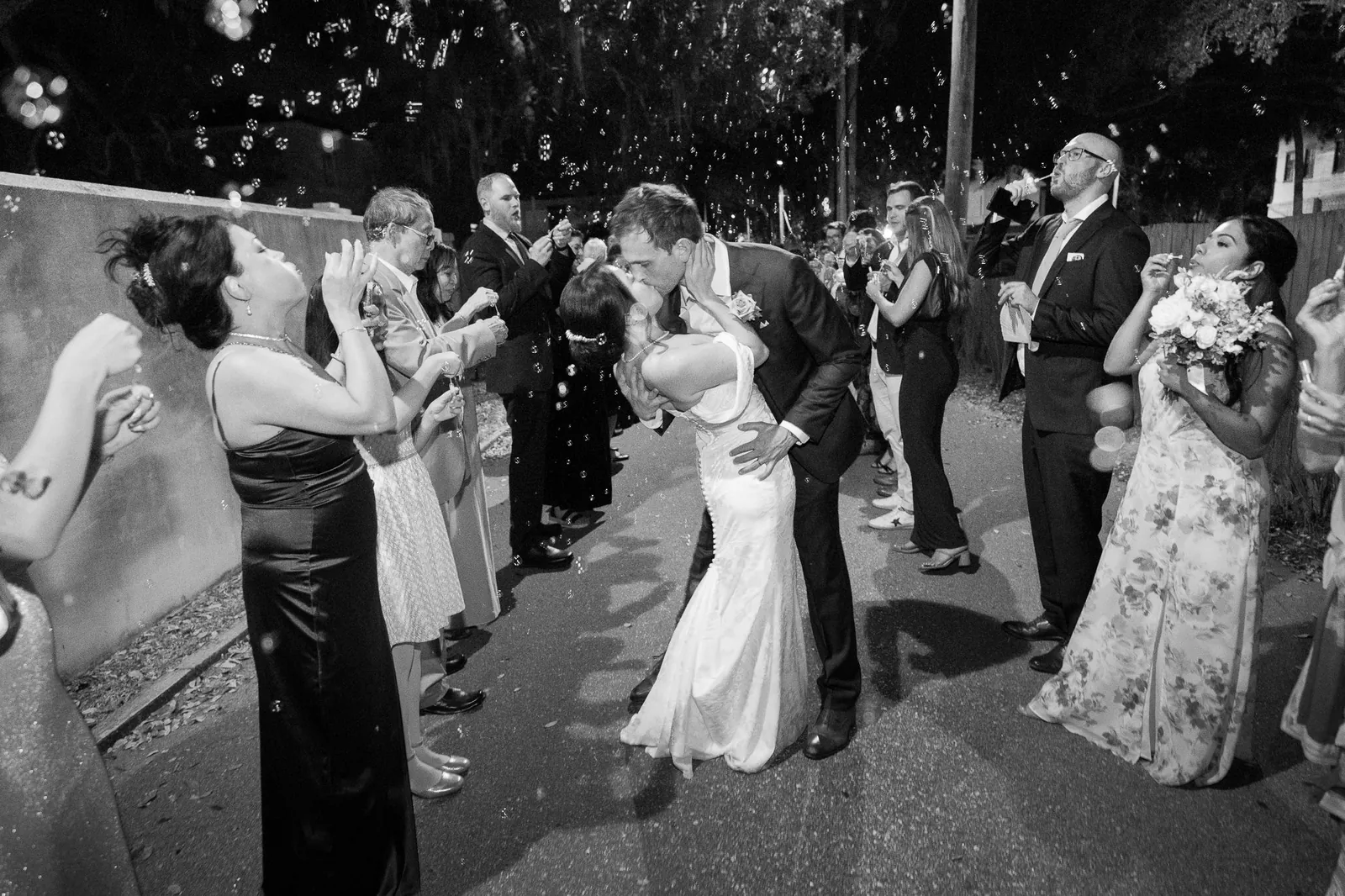 Bubble exit kiss in black and white at the Oldest House wedding