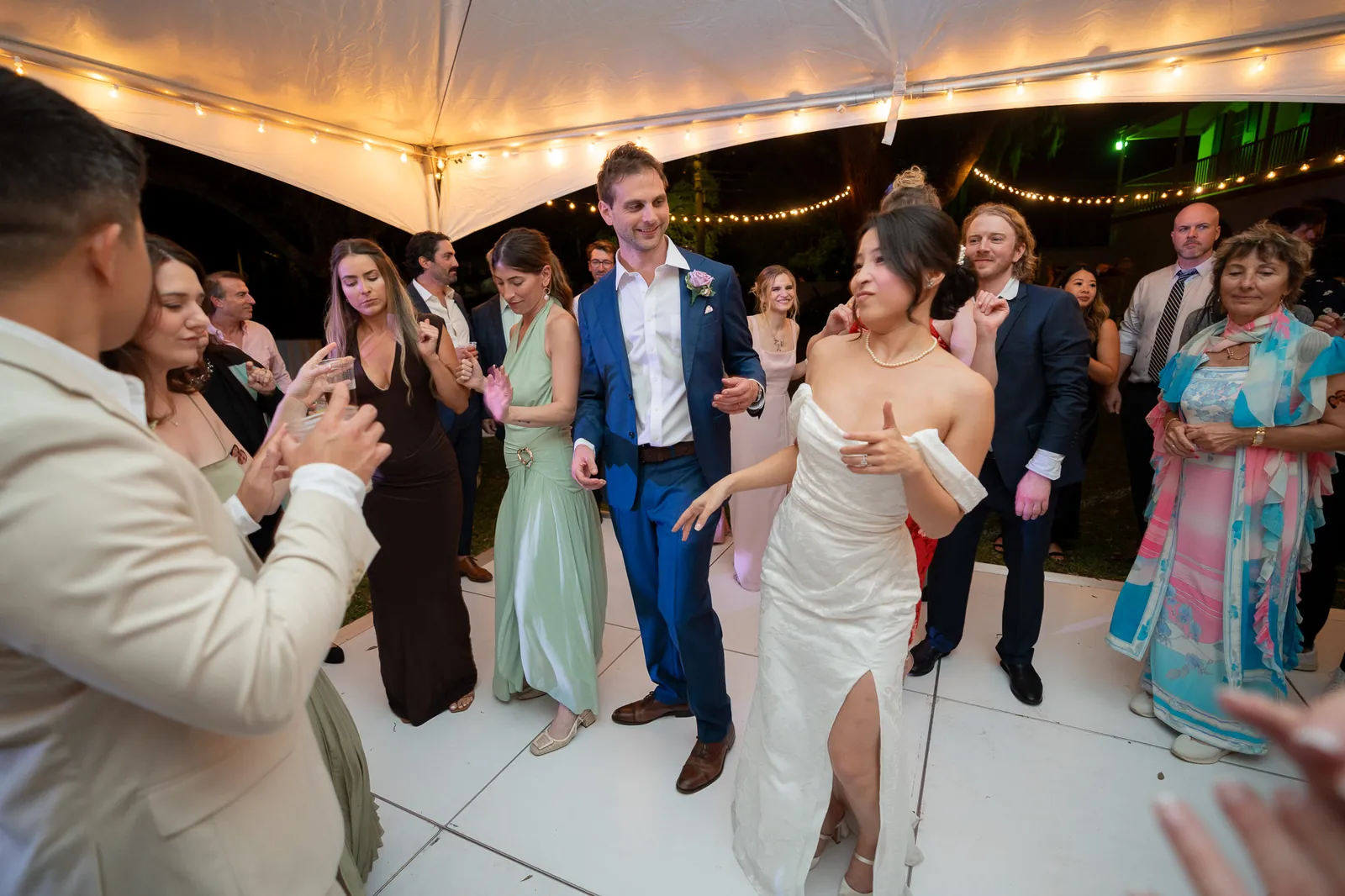 Couple dancing with guests under tent at the Oldest House reception