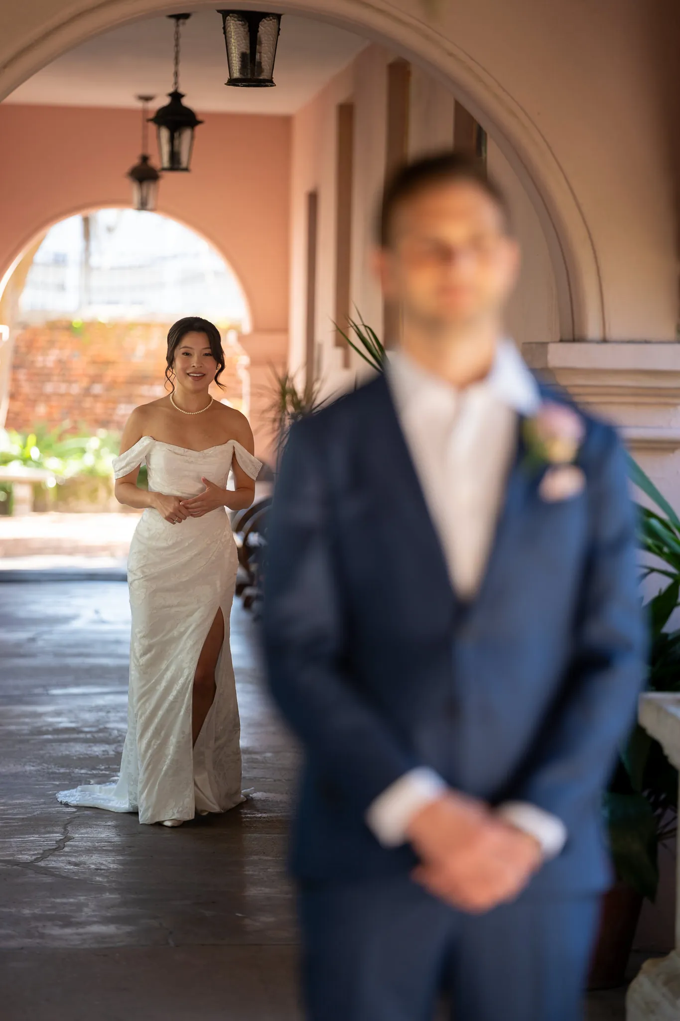 First look bride Binh approaching groom under archway at the Oldest House