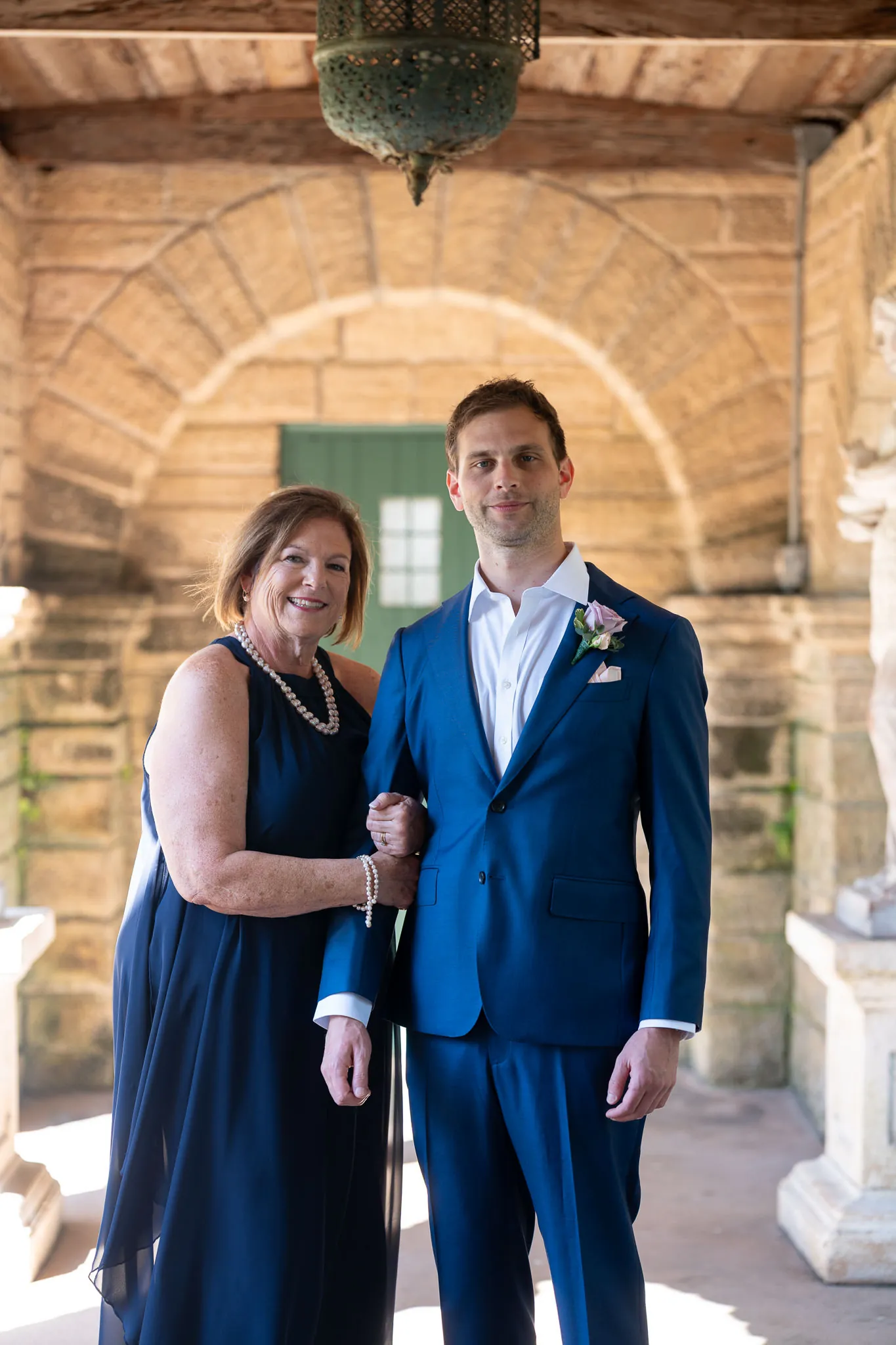 Groom Nico with his mother under coquina archway at the Oldest House