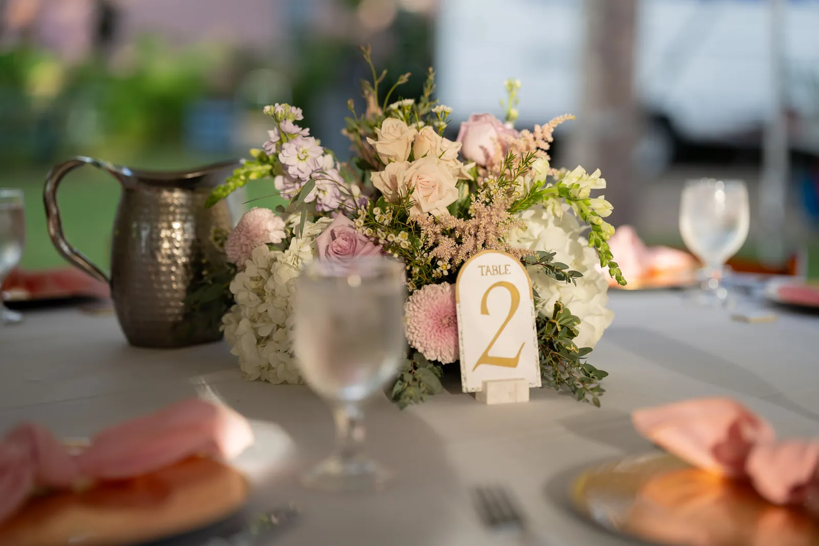 Reception centerpiece with blush and lavender florals and gold table number