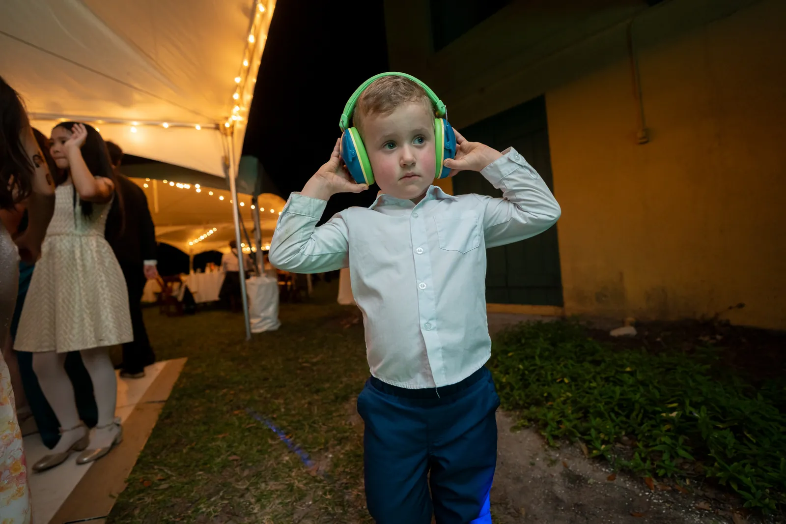 Ring bearer with noise-canceling headphones at the Oldest House reception