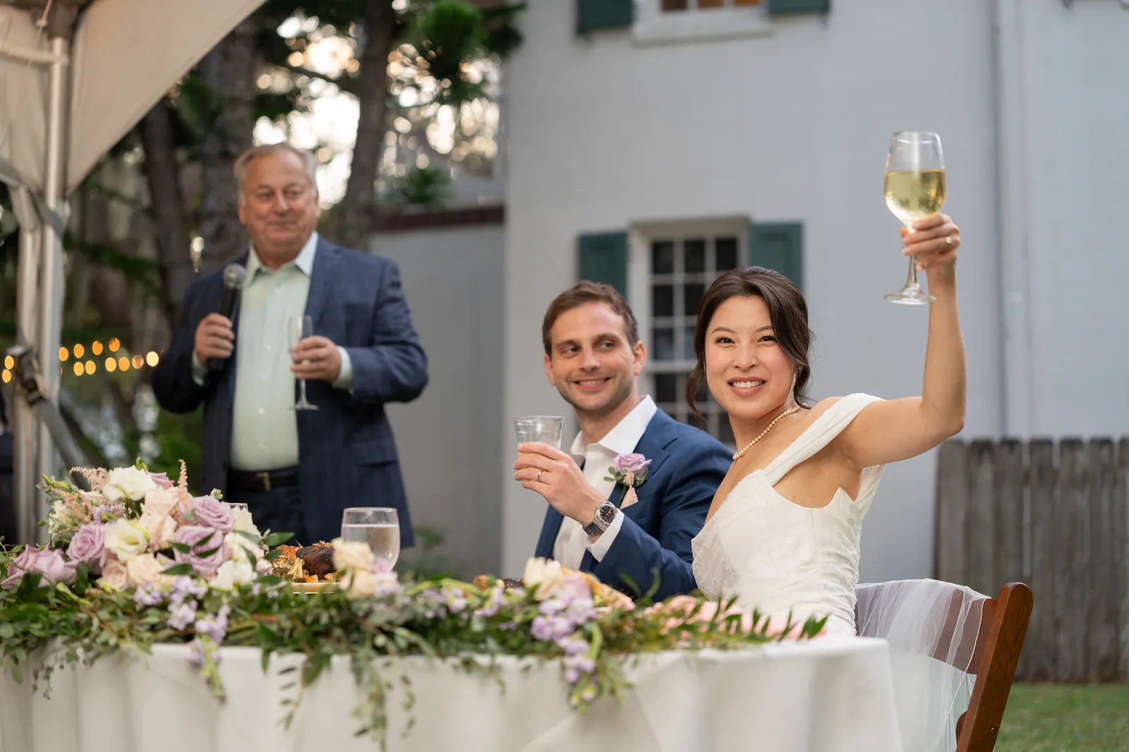 Bride Binh raising glass during toast at the Oldest House reception