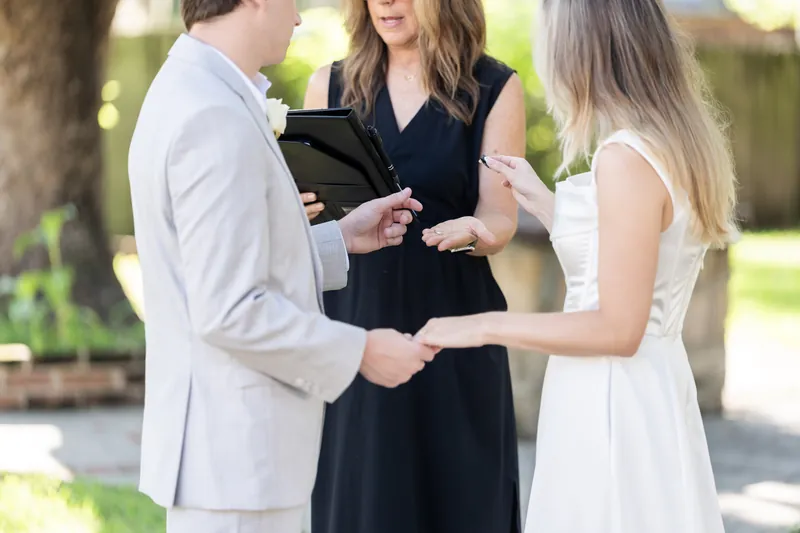 The officiant guides Blair and Devin through their wedding rings in front of witnesses at St. Francis Park.