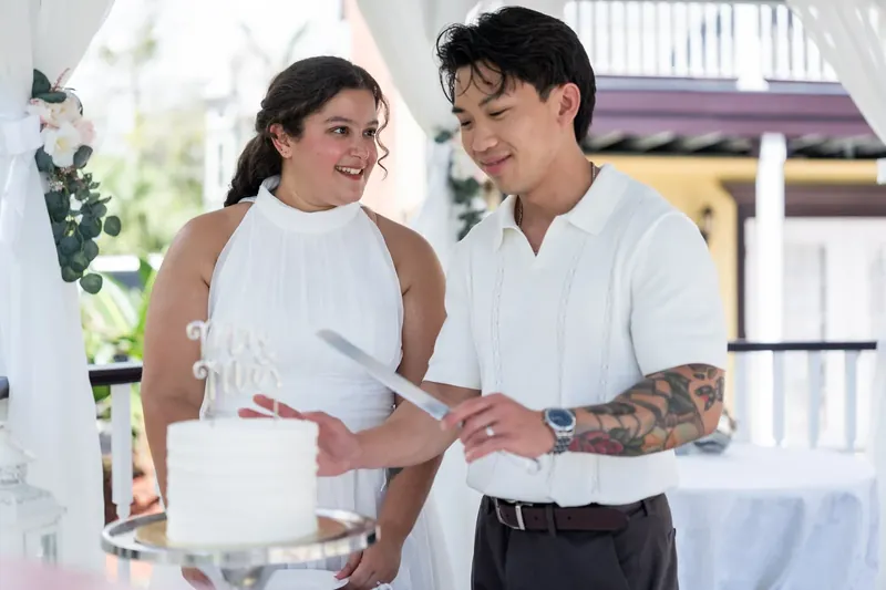 Blossom and Chris stand together at the Bayfront Marin House, exchanging rings during their ceremony in white attire.