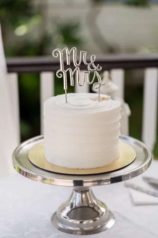 White cake topped with "Mr & Mrs" script sits on a silver pedestal at Bayfront Marin House, St. Augustine.