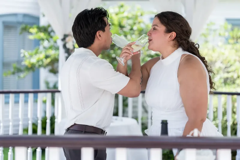 Blossom and Chris feed each other cake on a railed balcony overlooking the water at Bayfront Marin House, St. Augustine.