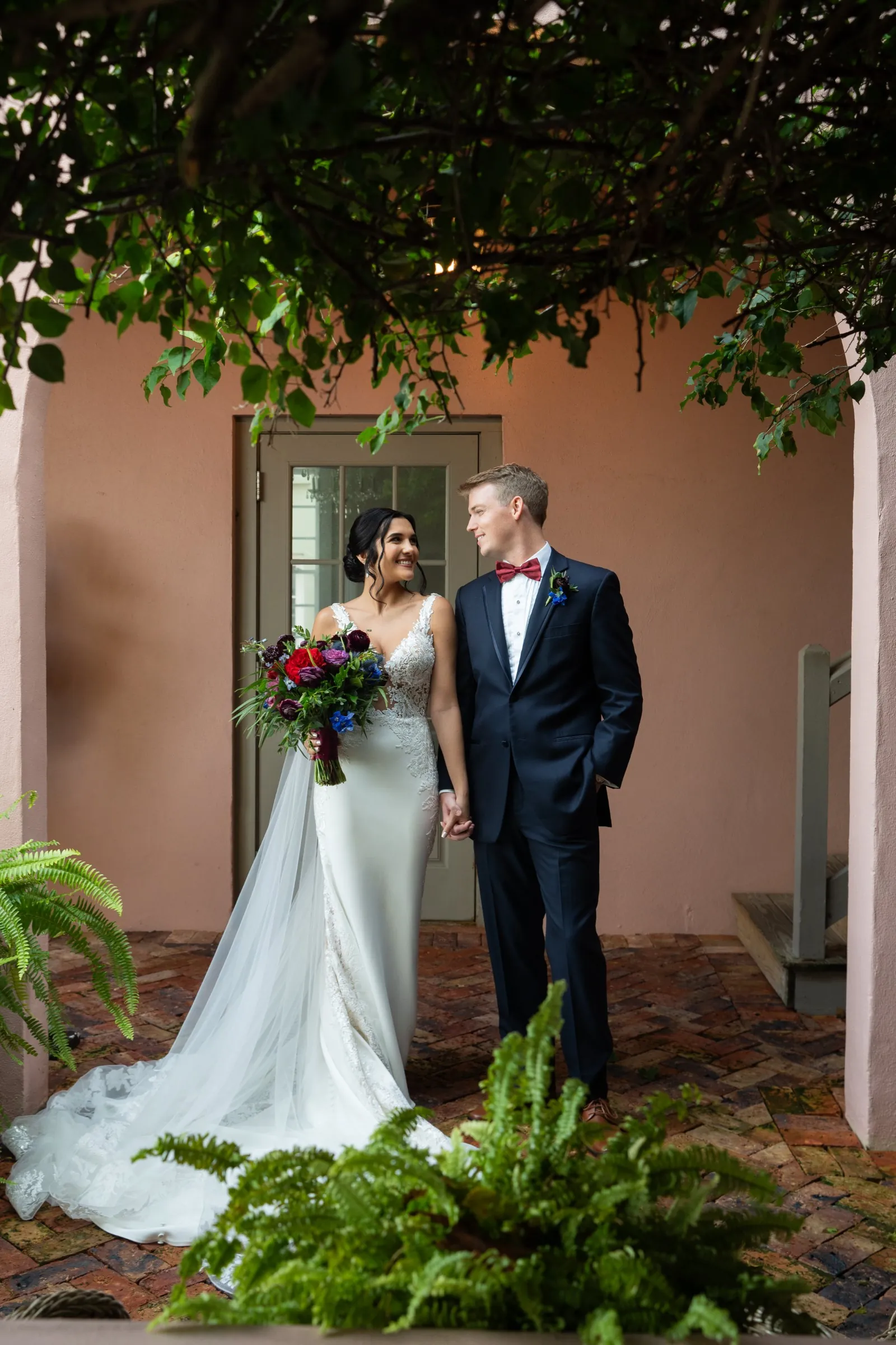 Bri and Nick portrait in courtyard with brick pathway at The White Room