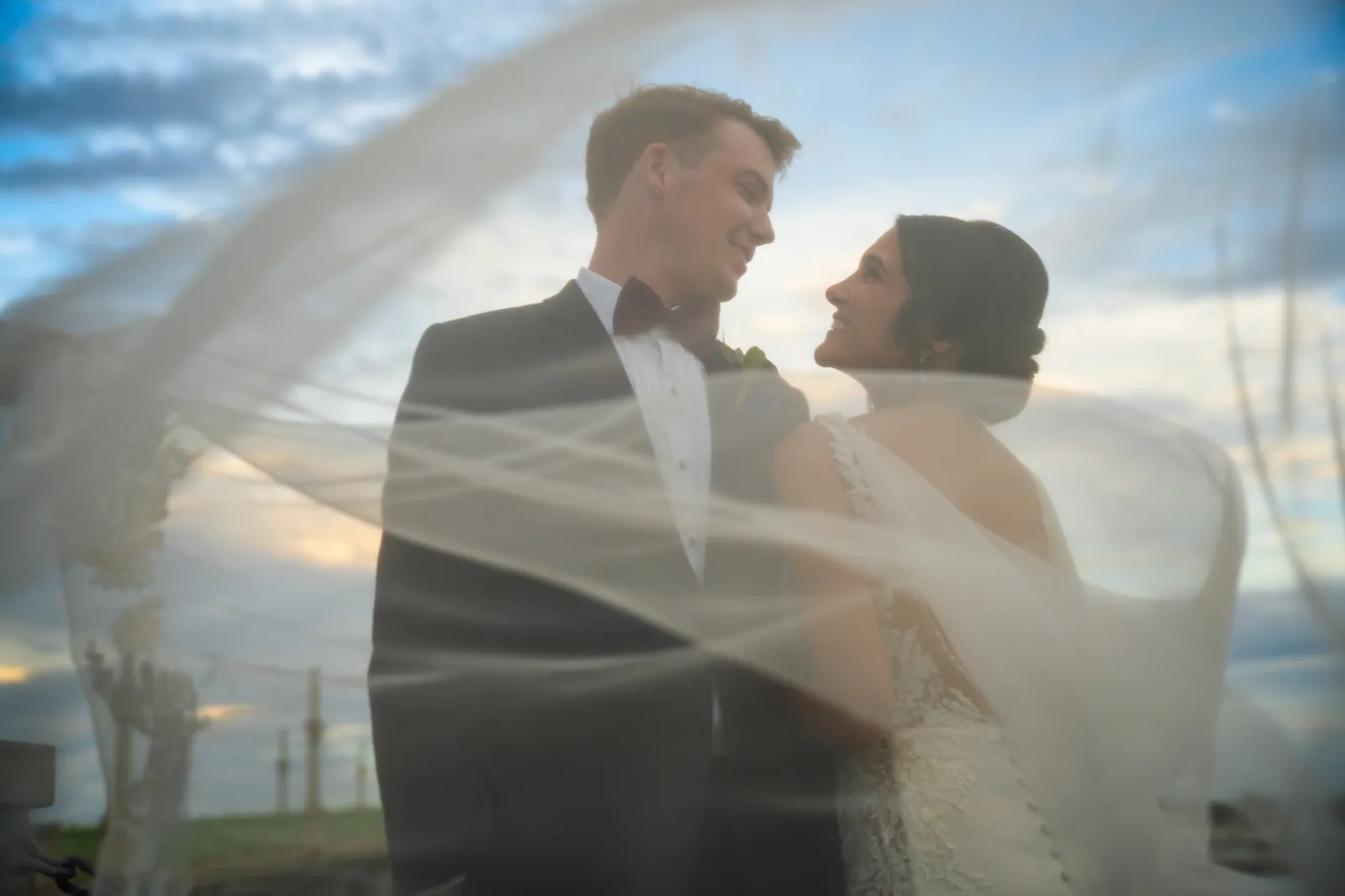 Bri and Nick portrait with veil flowing at sunset on the bayfront