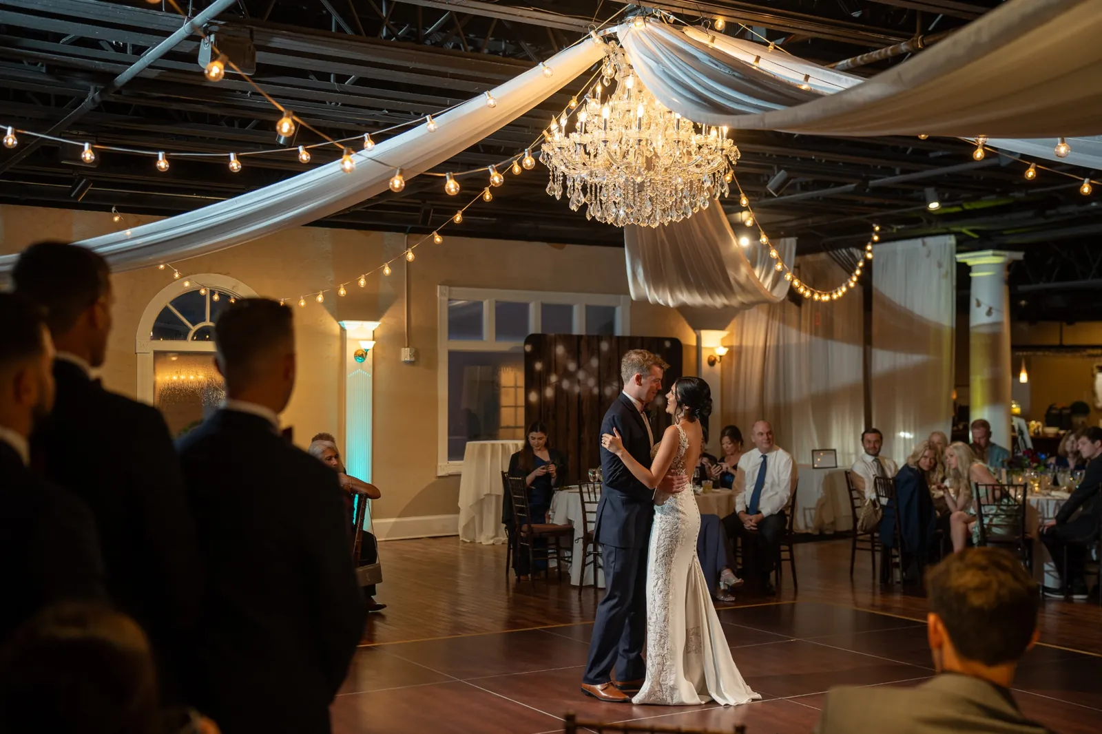 Bri and Nick first dance under chandelier with draping at The White Room