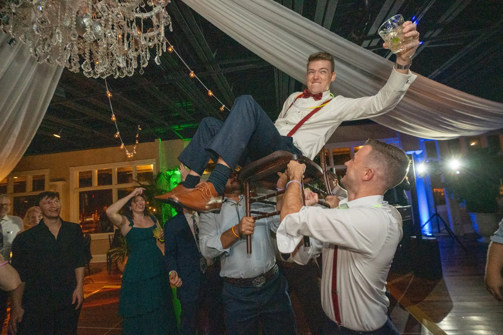 Groom Nick lifted on chair during hora celebration at The White Room