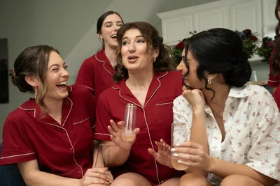 Women in red pajamas laughing together at festive slumber party celebration
