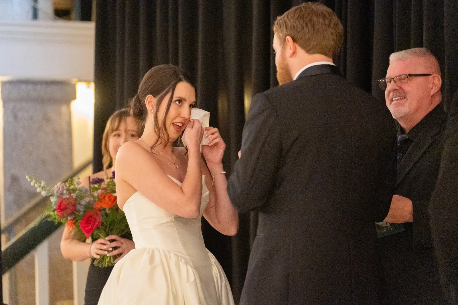 Bride wiping tears during emotional ceremony moment