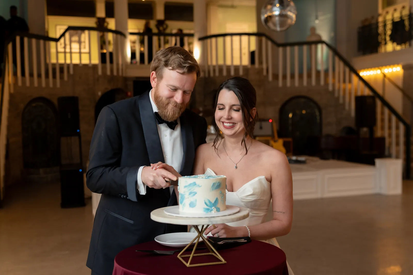 Cake cutting in Lightner Museum ballroom with staircases