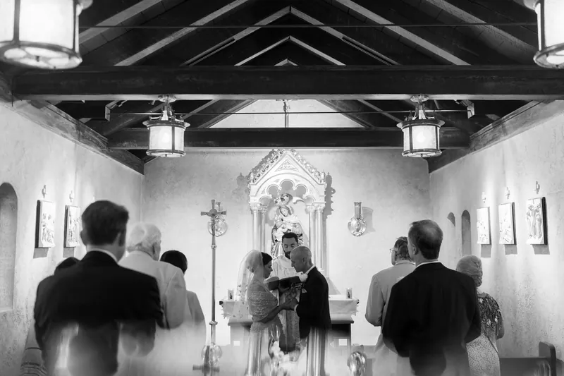 Guests stand and face the altar in black and white as Bridgid and Dan complete their ceremony.