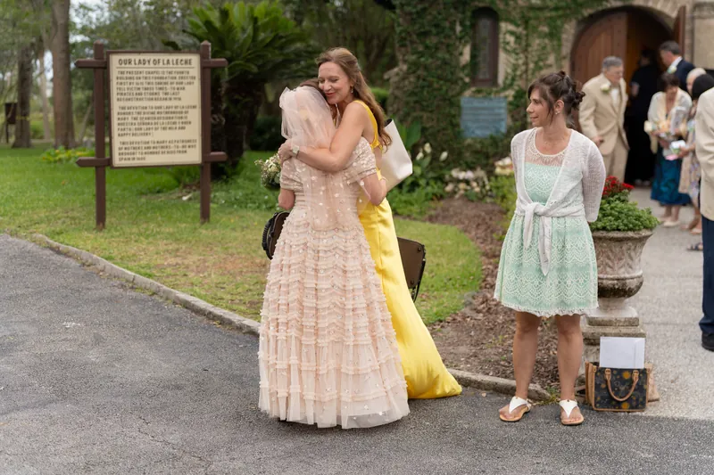Bridgid adjusts her pale pink pleated gown while guests gather at the shrine in St. Augustine.