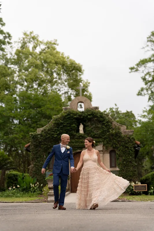 Dan and Bridgid walk hand-in-hand past the ivy-covered Mission chapel in St. Augustine.