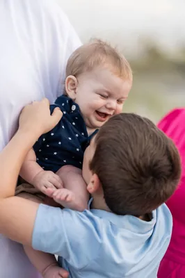 St. Augustine family photographer captures parents with three children smiling on beach path