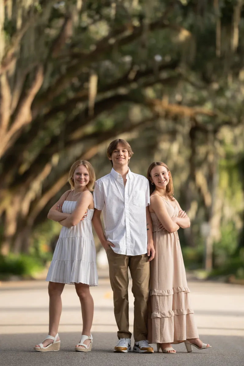 Siblings in fun back-to-back pose with arms crossed