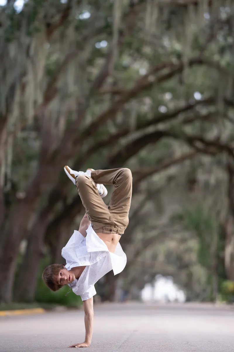Grandson doing one-handed handstand under the oaks