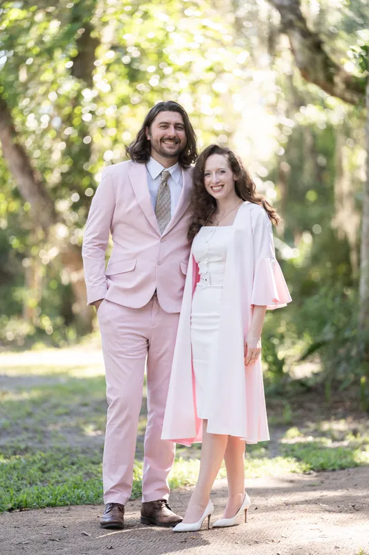 Cameron and Chris walk hand-in-hand down a tree-lined boardwalk path at Fort Mose in St. Augustine.