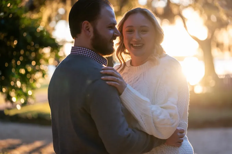 Carli and Jeff laughing together with sunset light behind them