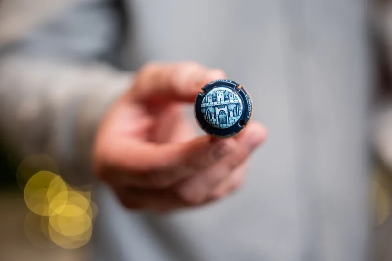 A hand holds a dark blue compass engraved with the Hyatt Vilano Beach logo against a blurred bokeh background.