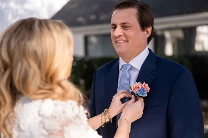 Chauncey pinning a boutonniere on James before the ceremony
