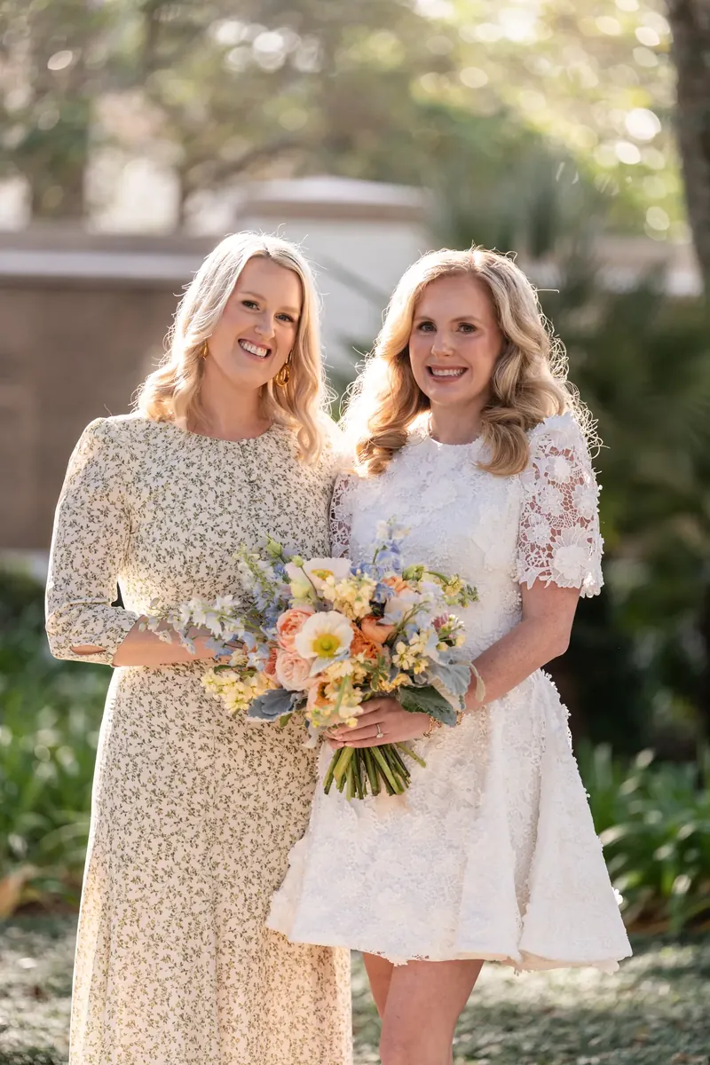 Chauncey and her sister smiling together with the bouquet