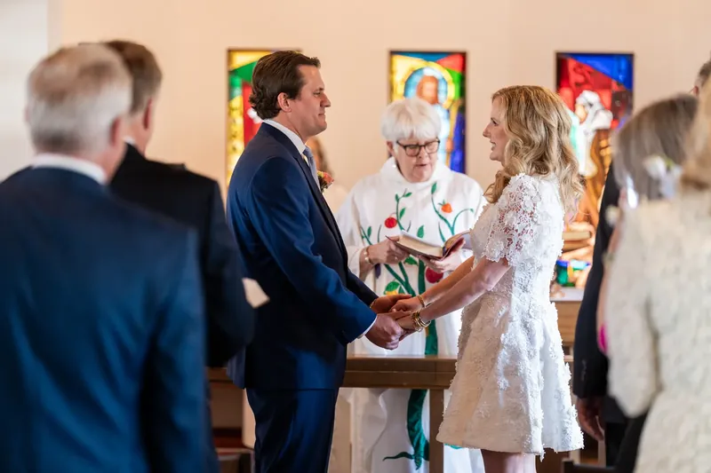 Chauncey and James exchanging vows with the officiant at the altar