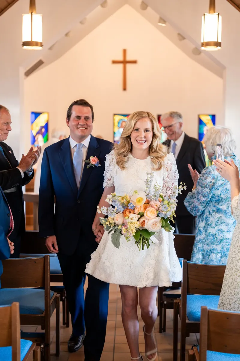 James and Chauncey stand at the altar beneath a wooden cross at Christ Church, surrounded by family.