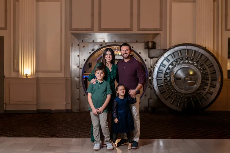 Family of four portrait in front of the iconic Treasury vault door in St. Augustine
