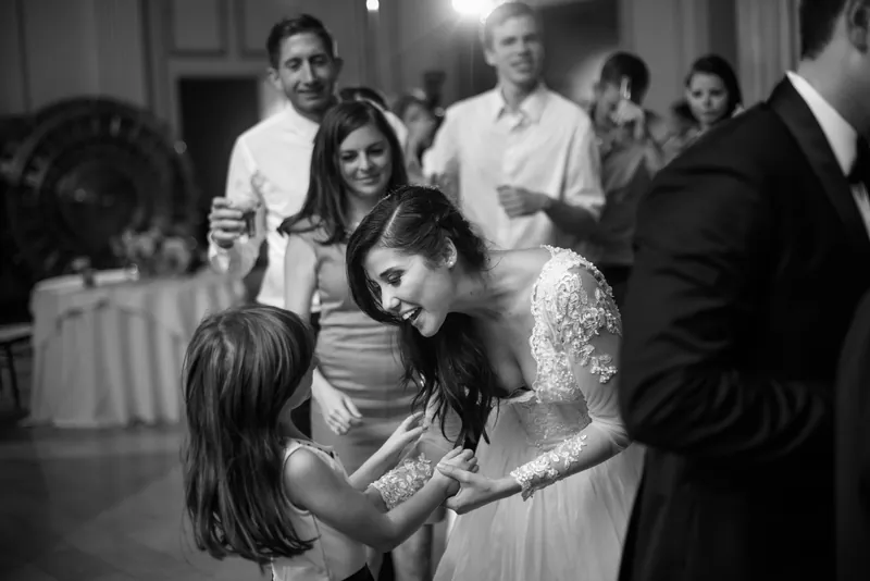 Choko bends down to greet a young child while Michael watches during the reception.