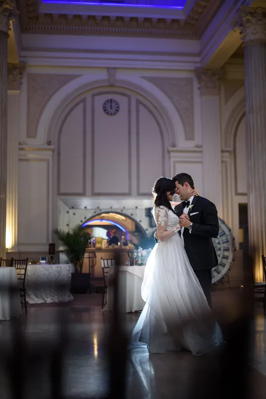 Choko and Michael share a first dance in the grand hall, her white gown flowing across the polished floor.