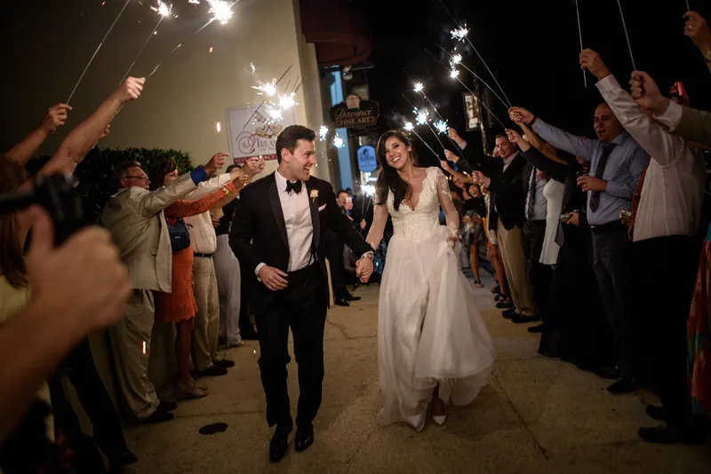 Choko and Michael walk through a sparkler tunnel as guests light up the night around them.