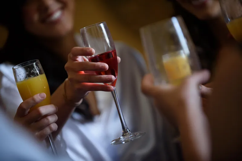 Guests hold champagne flutes and mimosas during a celebratory toast at Casa Monica Resort & Spa.