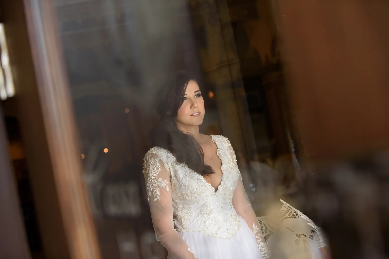 Choko in her beaded wedding gown gazes thoughtfully through a doorway at the resort.