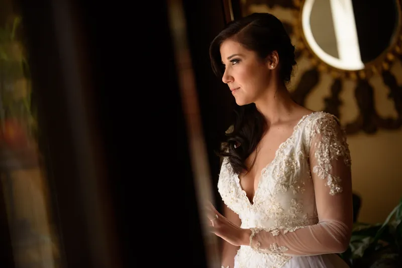 Choko stands in profile wearing her beaded white dress, warm evening light illuminating her face and updo.