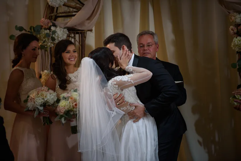 Choko and Michael share their first kiss at The Treasury on the Plaza as family applauds nearby in St. Augustine.