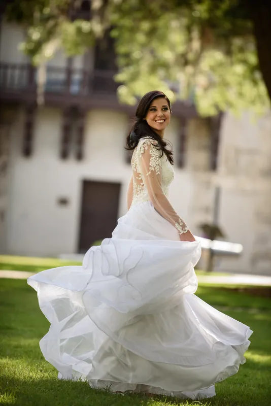 Choko twirls on the grass, her flowing white gown billowing around her, glancing back over her shoulder with a smile.
