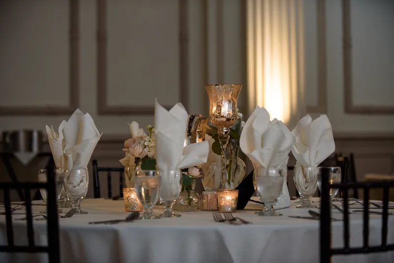 White tulips and gold-trimmed glassware adorn a reception table at The Treasury on the Plaza, St. Augustine.