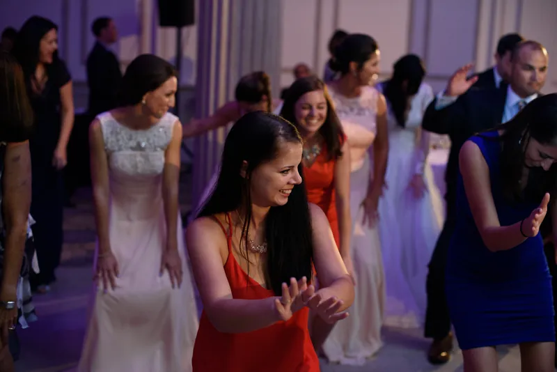 Wedding guests dance together under moody purple lighting at The Treasury on the Plaza during the reception.