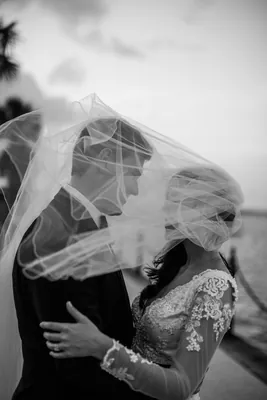 Michael lifts Choko in a dramatic dip along the waterfront at dusk, her white gown flowing as boats and bridges line