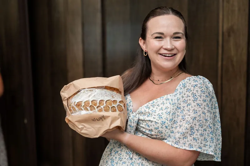 Cleo beams while holding a gold decorative bowl at the family gathering.