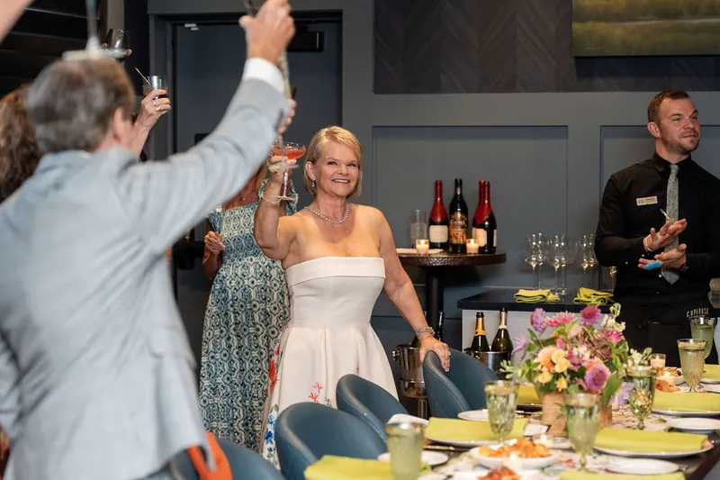 Someone captures a candid moment as Cleo in a white strapless dress laughs with guests near the bar at Chophouse at Nocatee.