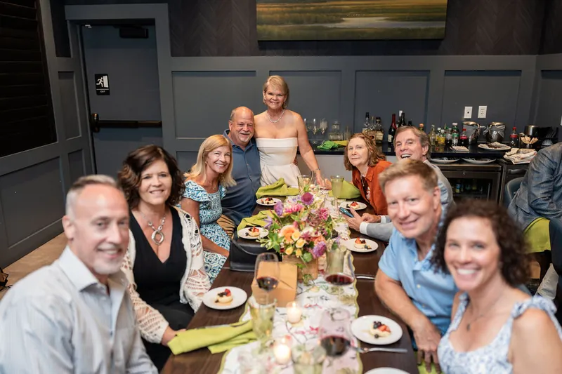 A large party gathers around a decorated dining table at the restaurant venue.