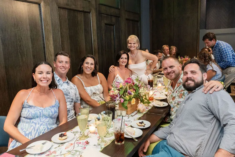 Guests laugh and relax together at the dinner table during the evening.