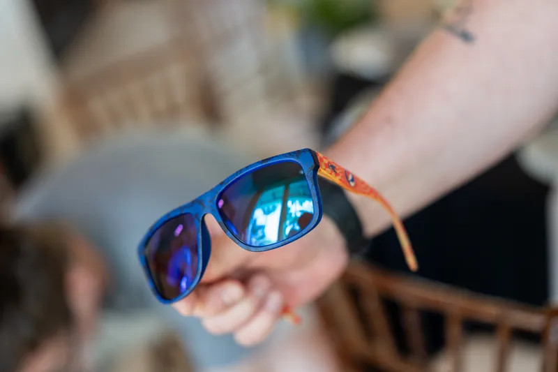 A guest displays blue mirrored sunglasses with an orange band during the celebration.