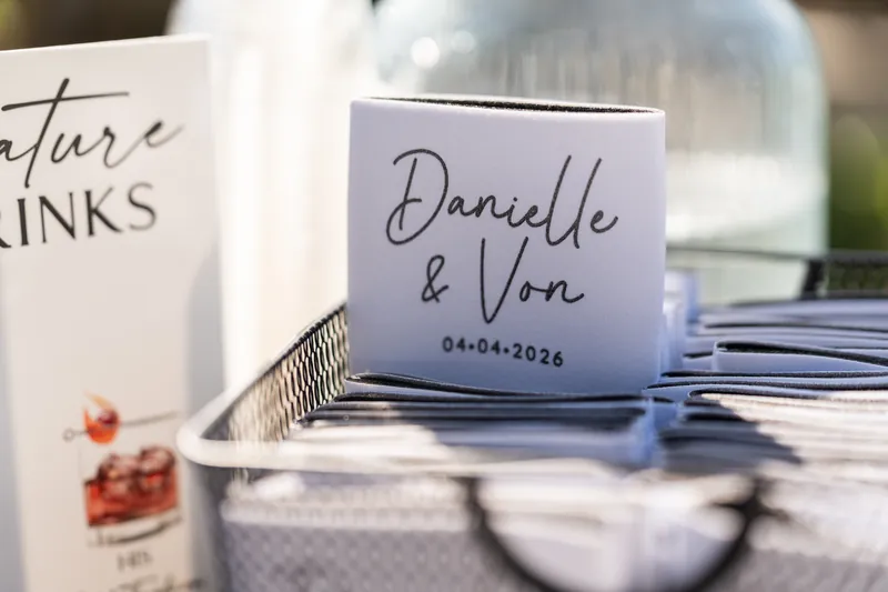 White napkin printed with "Danielle & Von 04.04.2026" on a place setting.
