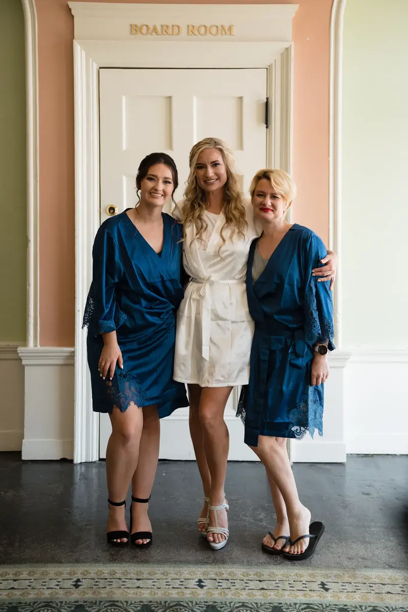Bride with bridesmaid and mother in matching robes before getting ready